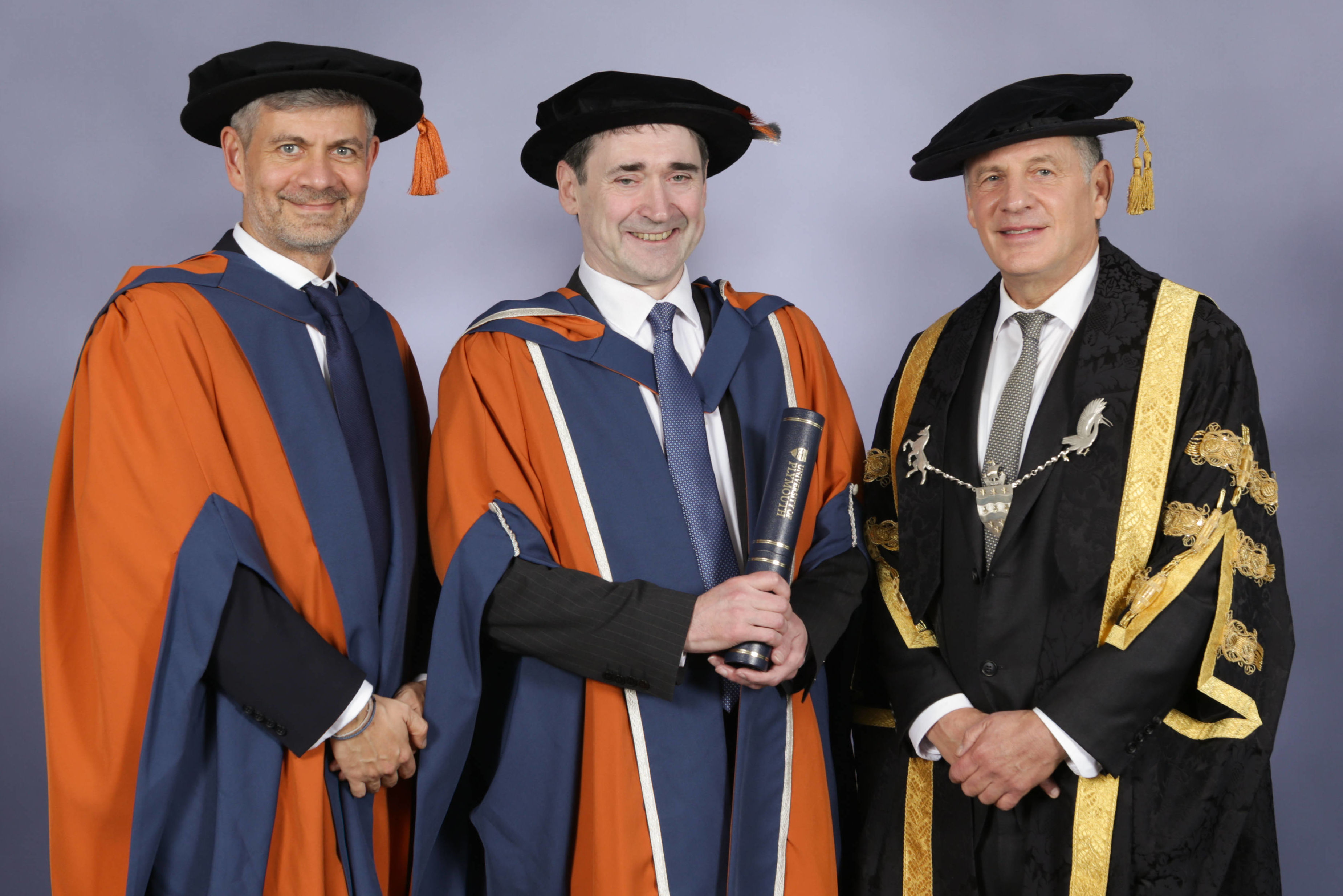 Alastair Revell, Doctor of Science (honoris causa) with Professor Bogdan Ghita (left) and The Lord Kestenbaum, Chancellor, University of Plymouth (right).