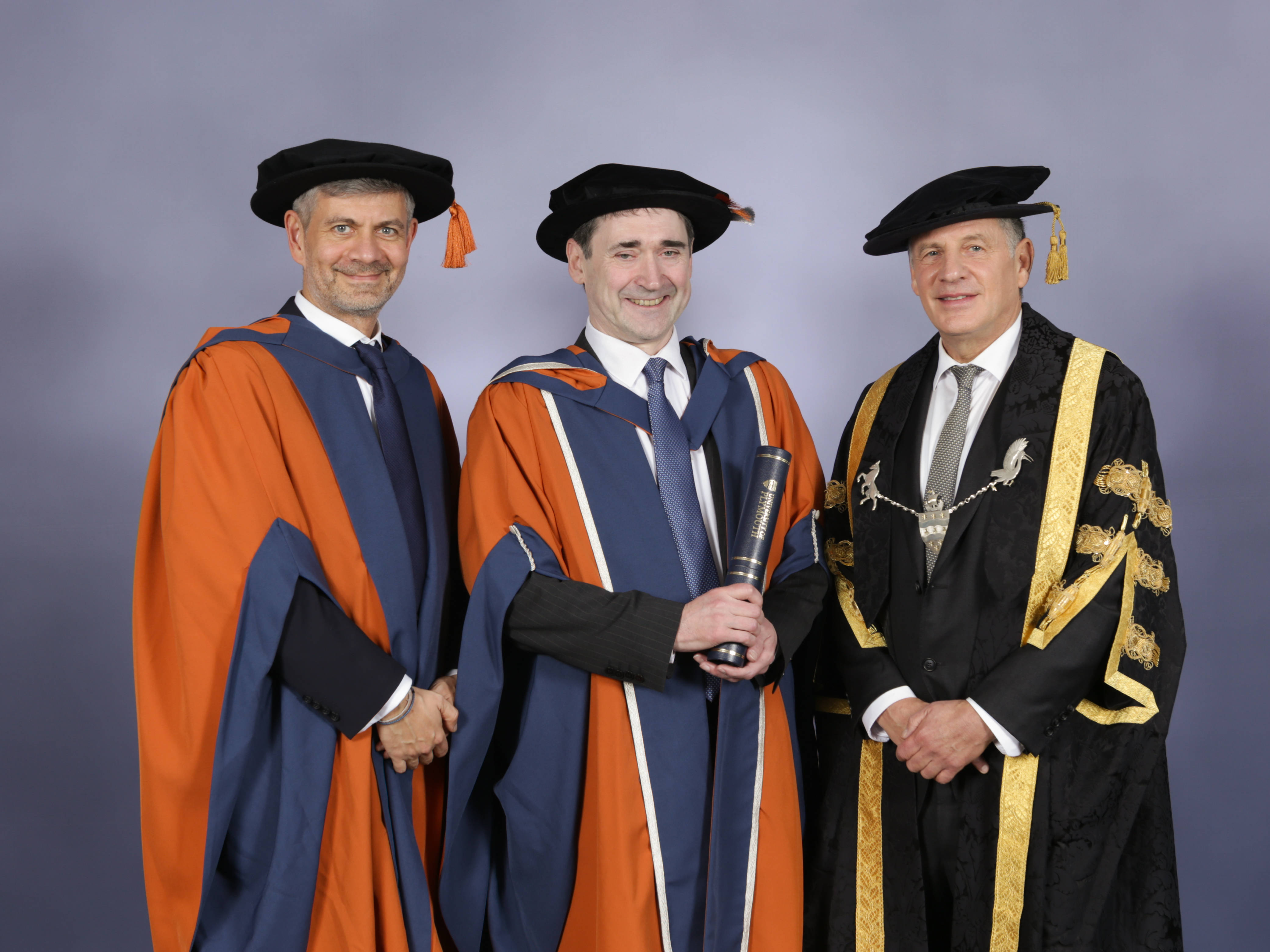 Alastair Revell, Doctor of Science (honoris causa) with Professor Bogdan Ghita (left) and The Lord Kestenbaum, Chancellor, University of Plymouth (right).